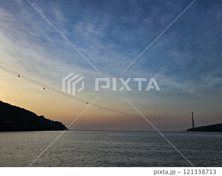 A beautiful sunset over the ocean with a bridge in the distance A beautiful sunset over the ocean with a bridge in the distance 121338713