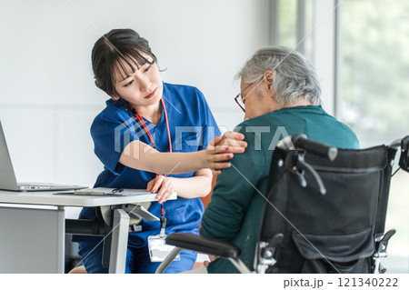 肩こり・肩を痛がる高齢者・シニア女性と介護施設・病院で働く整形外科の医師・看護師・介護福祉士 121340222