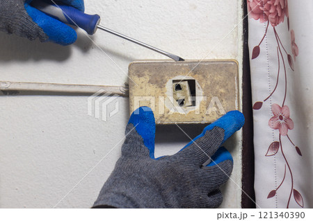 Electrician is fixing old sockets of a residential. Electrician is fixing old sockets of a residential. 121340390
