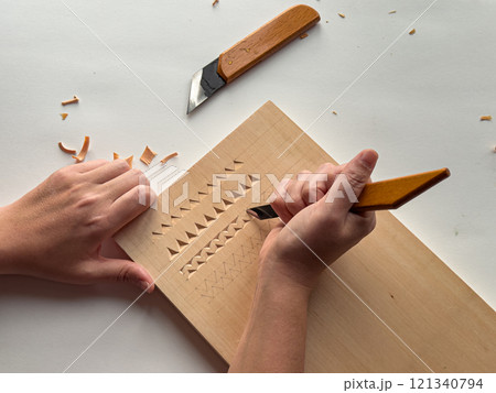Close up of detailed wood carving process with tools 121340794