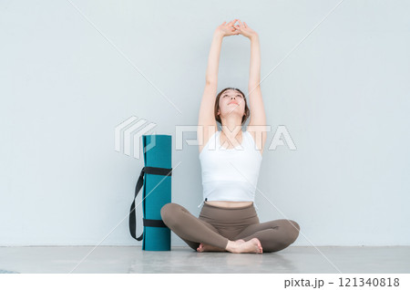 深呼吸するヨガウェア・スポーツウェアを着た女性とヨガマット 121340818