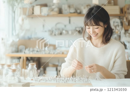 笑顔でハンドメイドアクセサリーを制作する女性 笑顔でハンドメイドアクセサリーを制作する女性 121341030