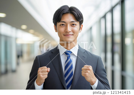 自信のある表情で両手を握りしめるスーツ姿の男性ビジネスマン 121341415
