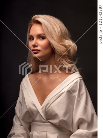 Studio photo portrait of a young pretty blonde on a dark background, close-up portrait of a woman Studio photo portrait of a young pretty blonde on a dark background, close-up portrait of a woman 121342297