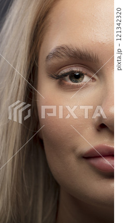 Studio photo portrait of a young pretty blonde on a dark background, close-up portrait of a woman 121342320