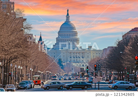 The US Capitol Dome overlooking a busy street with traffic under a colorful sunset in Washington DC 121342605