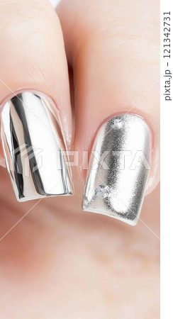 Metallic silver chrome nails closeup with rhinestone accents, vertical background 121342731