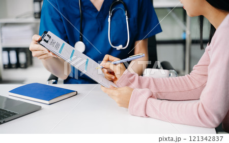 Female doctor using clipboard is delivering great news talk discuss results or symptoms with female patient in clinic or hospital 121342837