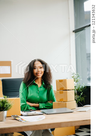 Young business owner woman prepare parcel box and standing check online orders for deliver 121343632