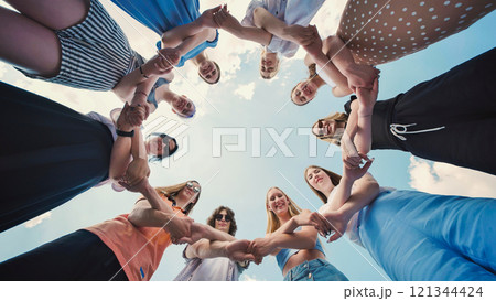 Young schoolchildren make a large circle from their hands. A joyful image of friendship and empowerment, radiating positive energy and hope. Young schoolchildren make a large circle from their hands. A joyful image of friendship and empowerment, radiating positive energy and hope. 121344424