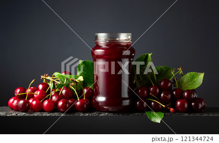 Cherry jam and fresh berries on a black background. 121344724