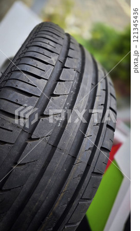 detailed image of a brand new car tire showcasing its intricate tread pattern for enhanced grip and performance 121345436
