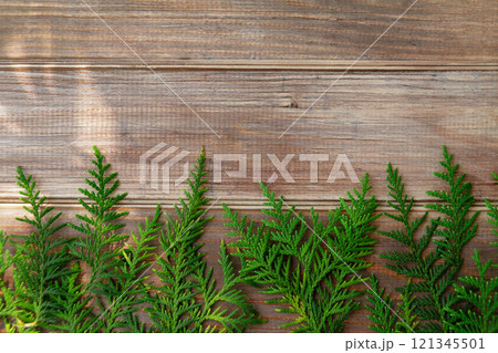 brown old wooden table background with green thuja branches, copy space 121345501