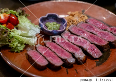Medium rare sliced rib eye meat served on plate with vegetable 121345951