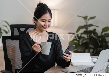 Young Accountant Working on Financial Documents in Modern Office Setting with Laptop and Smartphone Young Accountant Working on Financial Documents in Modern Office Setting with Laptop and Smartphone 121346275