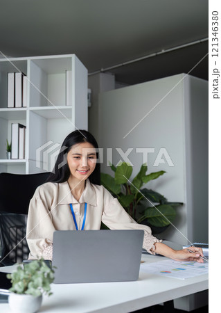 Professional Businesswomen Submitting Work on Laptop in Modern Office Environment with Focused Expression and Productive Atmosphere Professional Businesswomen Submitting Work on Laptop in Modern Office Environment with Focused Expression and Productive Atmosphere 121346380