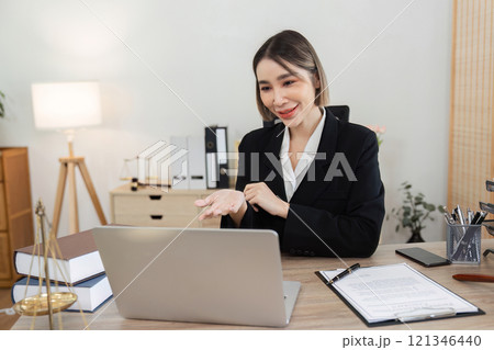 Young Female Lawyer Introducing Business Contract Law in a Modern Office Setting with Laptop and Legal Documents Young Female Lawyer Introducing Business Contract Law in a Modern Office Setting with Laptop and Legal Documents 121346440