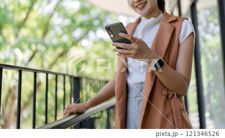 Confident Businesswoman Analyzing Stock Market Trends on Smartphone in Modern Office Setting Confident Businesswoman Analyzing Stock Market Trends on Smartphone in Modern Office Setting 121346526