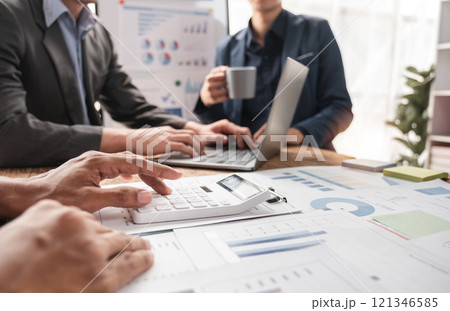 Business Team Collaborating on Project with Charts and Graphs in Modern Office Setting Business Team Collaborating on Project with Charts and Graphs in Modern Office Setting 121346585