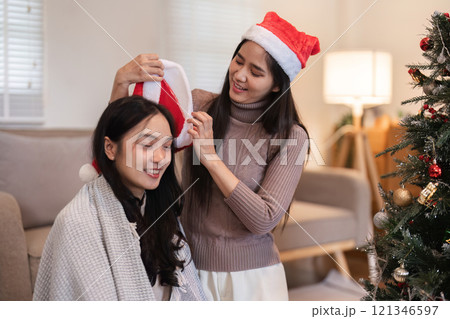 Young Woman Joyfully Prepares Her Room for a Cozy Christmas Celebration with Festive Decorations and Holiday Spirit 121346597