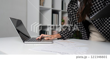 Close-Up of Businesswoman Typing on Laptop in Modern Office Setting with Focus on Hands and Technology 121346601
