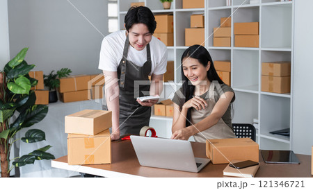 Couple Working Together to Sell Merchandise Online and Packing Boxes in a Modern Home Office 121346721