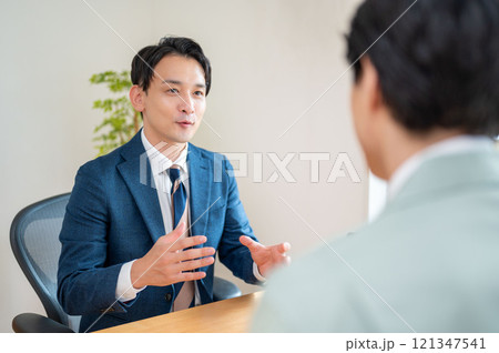 PCで説明をするビジネスマン 121347541