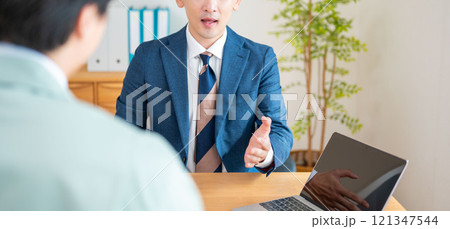 PCで説明をするビジネスマン PCで説明をするビジネスマン 121347544