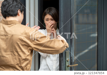 玄関先で訪問者に怯える女性 121347854