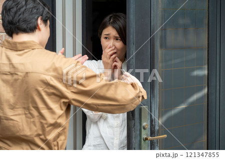 玄関先で訪問者に怯える女性 121347855