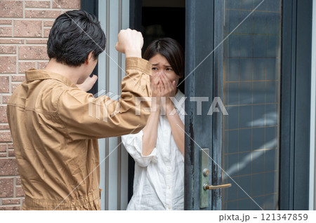 玄関先で訪問者に脅されている女性 玄関先で訪問者に脅されている女性 121347859