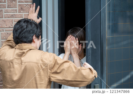 玄関先で訪問者に脅されている女性 玄関先で訪問者に脅されている女性 121347866