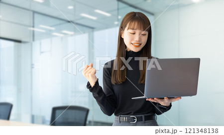 パソコンを見てガッツポーズをする女性・ビジネスウーマン 121348138
