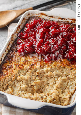 Rice and liver casserole Maksalaatikko with Cranberry sauce closeup on the baking dish. Vertical Rice and liver casserole Maksalaatikko with Cranberry sauce closeup on the baking dish. Vertical 121348294