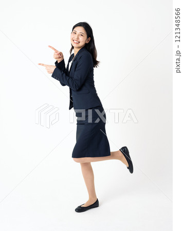 横を指差すスーツを着た若い女性の全身ポートレート 横を指差すスーツを着た若い女性の全身ポートレート 121348566