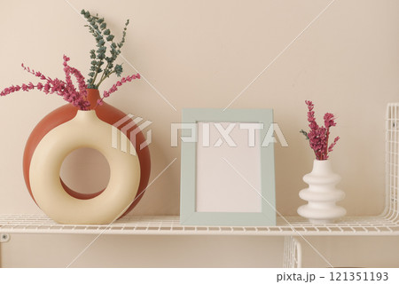 Stylish and modern decorative vases filled with dried flowers on a shelf Stylish and modern decorative vases filled with dried flowers on a shelf 121351193