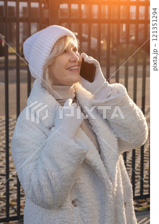 Elegant senior woman wearing winter clothes making phone call outdoors 121351294