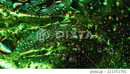 Glowing dew. Moisture metal. Green defocused illuminated shiny area covered with water drops foil effect. Smooth humidity glass background texture. Glowing dew. Moisture metal. Green defocused illuminated shiny area covered with water drops foil effect. Smooth humidity glass background texture. 121351701
