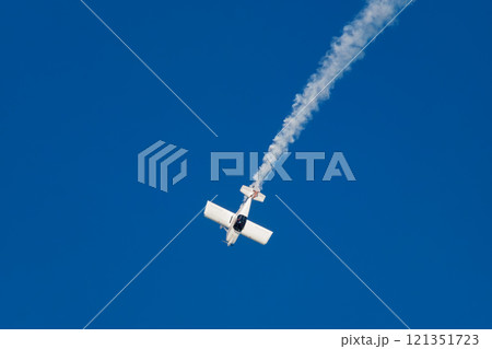 Stunt aerobatic plane performing stunts in air Stunt aerobatic plane performing stunts in air 121351723