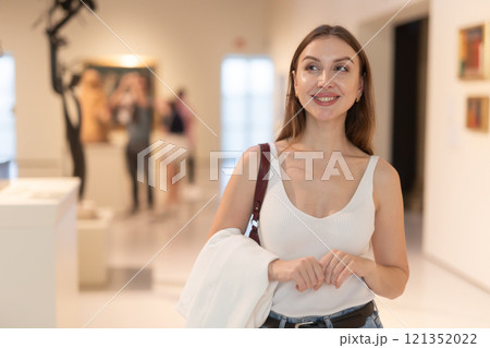 Woman studying exhibits in a museum 121352022