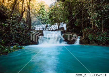 Scenic cascade waterfalls with clear blue water and wooden bridge in Central Sulawesi Scenic cascade waterfalls with clear blue water and wooden bridge in Central Sulawesi 121352451