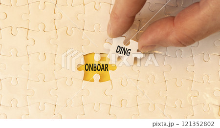 Onboarding success symbol. Concept word Onboarding on beautiful white puzzles. Beautiful yellow background. Businessman hand. Business onboarding success concept. Copy space. Onboarding success symbol. Concept word Onboarding on beautiful white puzzles. Beautiful yellow background. Businessman hand. Business onboarding success concept. Copy space. 121352802