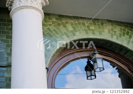 green street lamp on background of semicircular window  121352892