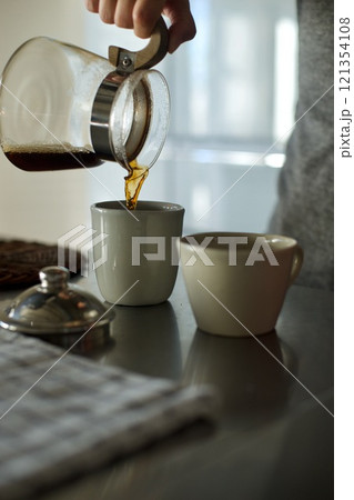 ドリップしたコーヒーをカップに注いでいるところ 121354108