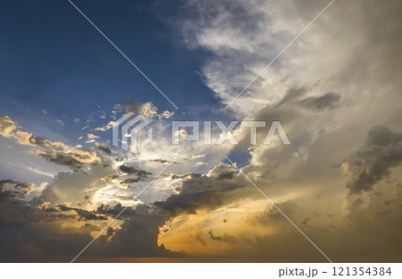Dramatic sunset sky covered with colorful yellow clouds. Panoramic skyscape 121354384