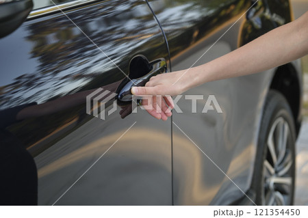 Closeup of driver hand opening car front door with touch ID finger imprint scanning technology. Vehicle safety concept Closeup of driver hand opening car front door with touch ID finger imprint scanning technology. Vehicle safety concept 121354450