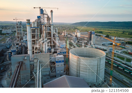 Cement plant with high factory structure and tower cranes at industrial production area. Manufacture, global industry and air pollution concept Cement plant with high factory structure and tower cranes at industrial production area. Manufacture, global industry and air pollution concept 121354500