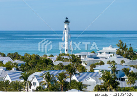 Boca Grande, Florida. Lighthouse on ocean shore for commercial vessels navigation. Expensive waterfront houses between green palm trees on Gasparilla Island Boca Grande, Florida. Lighthouse on ocean shore for commercial vessels navigation. Expensive waterfront houses between green palm trees on Gasparilla Island 121354520