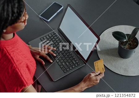 High angle shot of unrecognizable woman using touchpad and holding credit card while shopping online High angle shot of unrecognizable woman using touchpad and holding credit card while shopping online 121354872