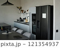 Modern kitchen with black and white smart kitchen appliances in front of graphite table with comfortable velour chairs 121354937